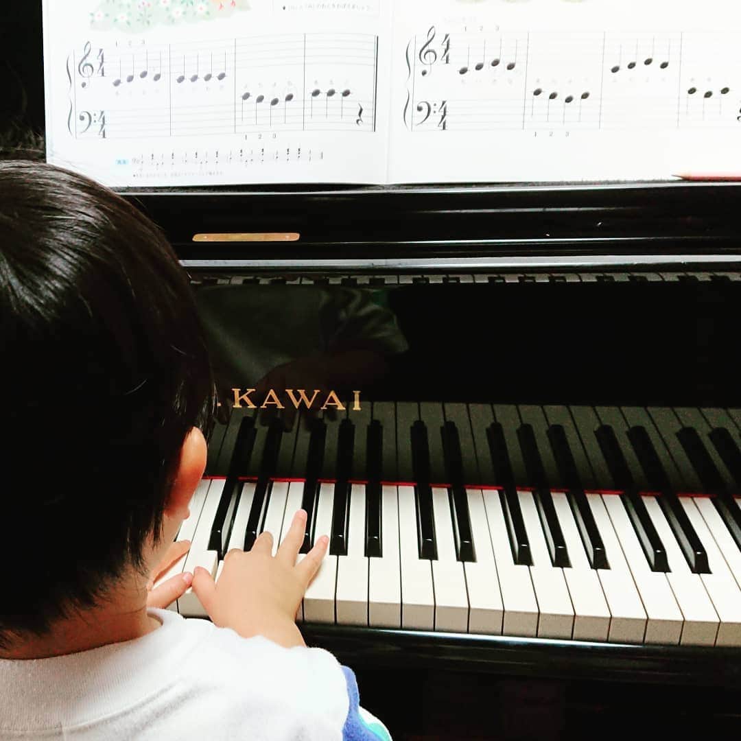 楽譜を見ながらピアノを弾く生徒