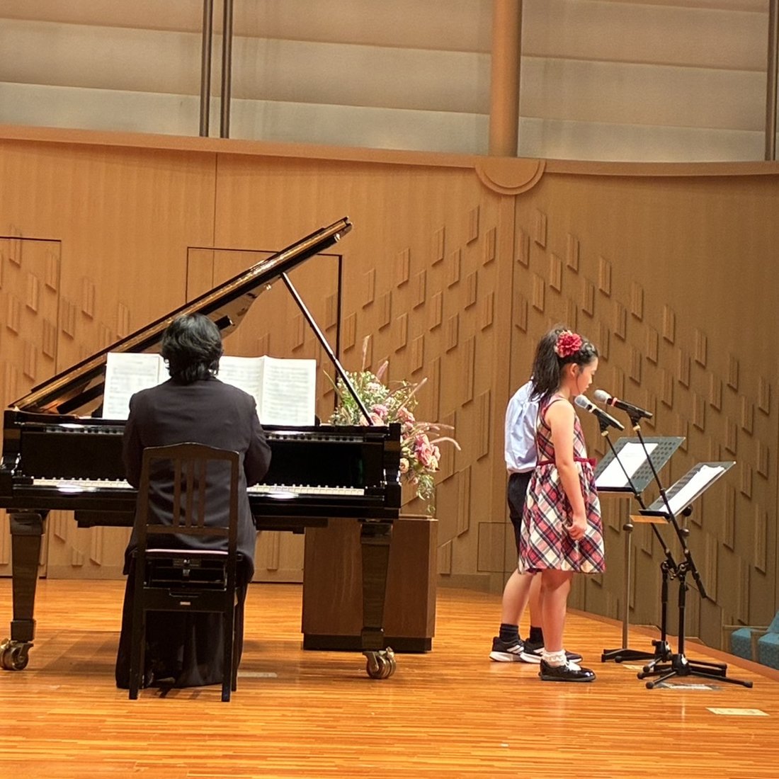 発表会でピアノの伴奏に合わせて歌う生徒